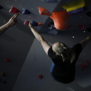 Woman Climbing while getting coached